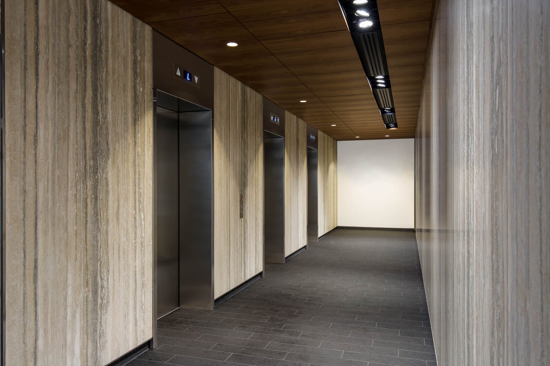 Renovated lobby at 475 West Georgia with new finishes, porcelain floor tiles, wood veneer bulkhead with recessed lighting